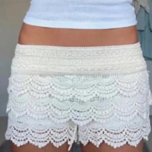 Vita virkade spets-shorts - Superfina vita shorts med bred midja och flera lager virkad spets i blommigt mönster. De har en feminin och romantisk look med volangkant nertill. Perfekta till sommaren och riktigt sköna att bära🤍passar även storlek xs, OBS första två bilderna är inte mina! Jag säljer flera liknande på min profil:)