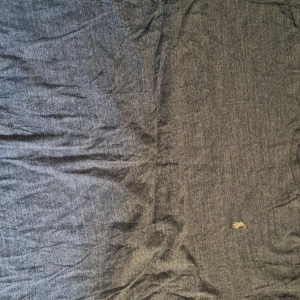 Blå pikétröja från Polo Ralph Lauren - Säljer en klassisk blå pikétröja från Polo Ralph Lauren i 100% bomull. Tröjan har korta ärmar och den ikoniska broderade loggan på bröstet. Perfekt för en stilren och avslappnad look.