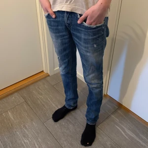 Dondup Jeans - Ett par Dondup George jeans med lite slitningar. Lita slitna vid fickorna men annars inga andra defekter. Jeansen är storlek 30