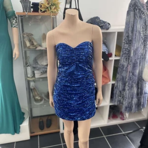 Blå glittrig kortklänning - Säljer en blå glittrig klänning som har en figurnära passform, finns i storlek 36-42, kan även erbjuda att skräddarsy klänningen efter preferens! 🥰