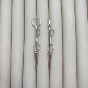 Silverfärgade örhängen med långa spetsar - Säljer ett par coola silverfärgade örhängen med lång, smal design och spetsiga hängen. Örhängena har ringdetaljer och ger en edgy känsla till din stil. Perfekta för dig som gillar unika accessoarer!