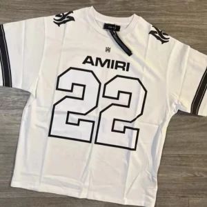 Vit t-shirt från Amiri - Säljer en vit t-shirt från Amiri med svart tryck av siffran 22 och logga framtill. T-shirten har svarta detaljer på axlarna och ränder på ärmarna. Klassisk passform och rund halsringning.
