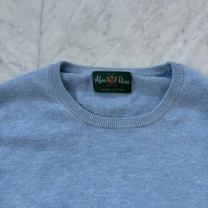 Ljusblå tröja från Alan Paine - Säljer en stilren ljusblå tröja från Alan Paine i mjuk bomull. Tröjan har en klassisk rund hals och långa ärmar med ribbade muddar vid ärmslut och nederkant. Perfekt för en avslappnad och snygg look. Den är i en kashmirmix