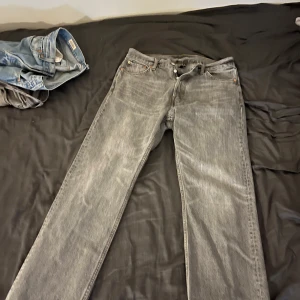 Weekday - space Grå jeansbyxor straight fit - Säljer ett par grå jeansbyxor med klassisk femficksdesign och raka ben. Byxorna har normal passform och stängs med knappar. Perfekta till vardags för en avslappnad stil.