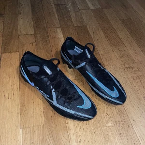 Fotbollsskor - Säljer ett par svarta Nike phantom gt elite fotbollsskor (ganska nya, endast testade). Inga fel alls. Storlek: 42.5