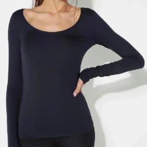 Svart långärmad topp - Säljer en stilren svart långärmad topp med rund halsringning. Perfekt för en enkel och elegant look. Passar bra till både jeans och kjol.