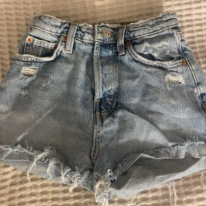 Ljusblå jeansshorts med fransar från Zara - Säljer mina ljusblå favvo jeansshorts från Zara eftersom som att jag tyvärr inte kan ha dom längre!Shortsen har slitna detaljer och knappgylf, supernyggt! Storlek 32.💘
