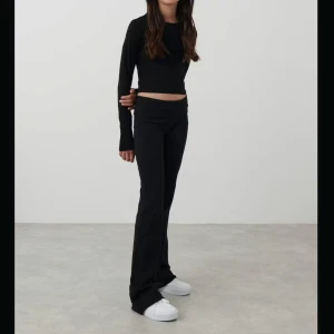 Low fold yoga pants - Säljer ett par svarta yoga pants  med låg midja och stretchigt material. Utsvängda ben och fold midja. Storlek 158/164. Slutsåld på ginas hemsida. 