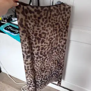 Säljer en snygg leopardmönstrad kjol från Zara i bruna och beige toner. Kjolen har rak passform och är i en mjuk, stretchig syntetblandning. Perfekt för dig som vill sticka ut med ett djurmönster!