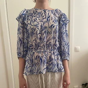 Sommrig blus - Snygg sommrig blus som år blå pch vit med zebra mönster och öppen rygg. Super skön och luftig!