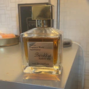 Barakkat Ambre Eve (Grand soir) - Elegant och lyxig parfym från Maison Fragrance World. Barakkat Ambre Eve kommer i en stilren, fyrkantig glasflaska med en gyllene kork. Doften är djup och varm, perfekt för den som söker något unikt och sofistikerat.