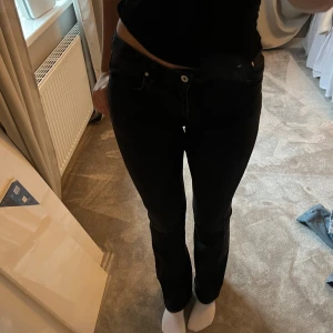 Svarta jeans - Snygga svarta jeans med en klassisk design. De har en normal passform och är perfekta för en stilren look. Jeansen har en knapp och dragkedja framtill. 84cm innerbenslängd