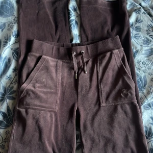 Bruna byxor från Juicy Couture - Säljer ett par bruna mjukisbyxor från Juicy Couture. Byxorna har snörning i midjan och praktiska fickor både fram och bak. Perfekta för en avslappnad stil! FINNS MATCHANDE TRÖJA!!