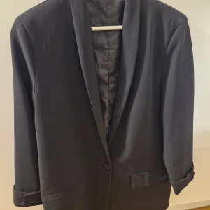 Svart kavaj/blazer - Elegant svart blazer  med klassisk design och enkel knäppning framtill.