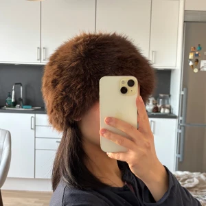 Brun pälsmössa - Snygg och varm brun pälsmössa perfekt för kyliga dagar. Mössan har en fluffig och mjuk textur som ger en lyxig känsla. Ett stilrent val för vintern.