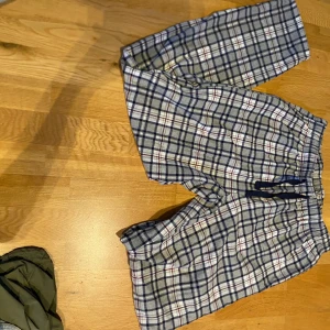 Rutig lounge byxor från Time to Lounge - Mysiga rutig lounge byxor från Time to Lounge i blått, vitt och rött. De har en bekväm elastisk midja med snörning för justerbar passform. Perfekta för avslappnade dagar hemma.