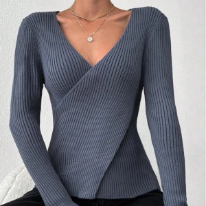 Grå ribbad omlottopp - Snygg grå ribbad omlottopp med v-ringning och långa ärmar. Perfekt för en stilren look.