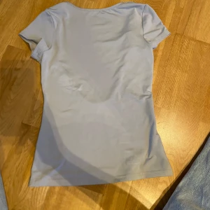 Weekday grå topp med öppen rygg - Säljer en enkel och stilren grå topp med korta ärmar. Perfekt för en avslappnad look. Toppen har en rund halsringning och är gjord i ett mjukt material.