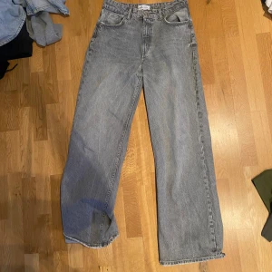 Grå baggy jeans från Zara - Säljer ett par grå baggy jeans från Zara. De har en avslappnad passform med hög midja och raka ben. Perfekta för en casual look. Tillverkade i ett klassiskt denimtyg.