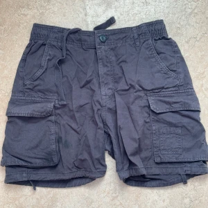 cargo shorts Bershka - Säljer ett par marinblåa cargo shorts från Bershka, köpta 2023, helt slutsålda överallt🌸 de är i storlek L men passar mig jätte bra som brukar ha 36/38, plagget kommer nytvättad och sturken🌸