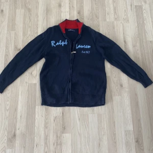 Zip från Ralph Lauren - Säljer en snygg mörkblå stickad tröja från Ralph Lauren med zip perfekt nu till våren                                     Finns dock ett litet hål se bild 4 men de märks inte när man använder den 