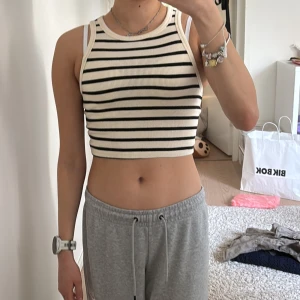 Randig ribbad topp - Säljer en snygg randig ribbad topp i svart och vit. Toppen är croppad och har en tight passform, perfekt för sommardagar.