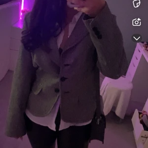 Grå kavaj med knappar - Snygg grå kavaj med klassisk design och knappar framtill. Perfekt för en stilren look. Passar bra över en skjorta för en mer formell stil.