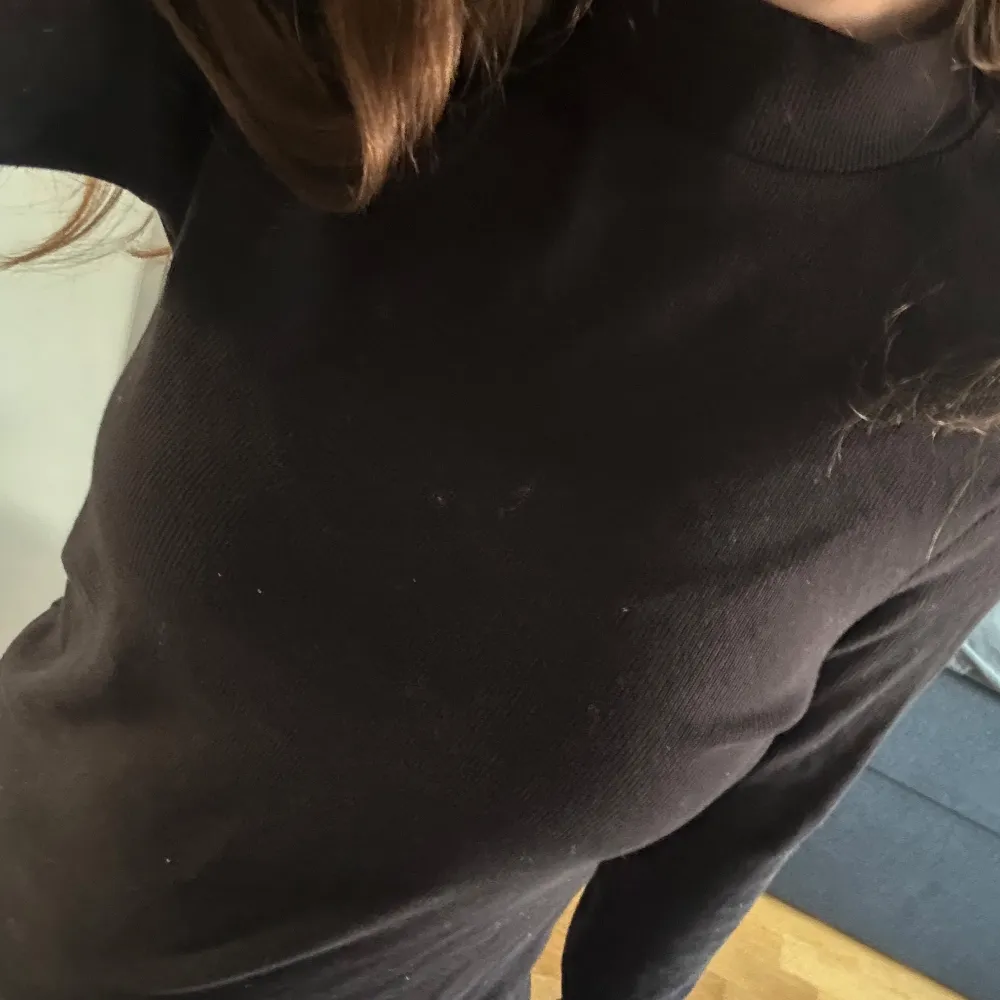 Säljer en stilren svart långärmad tröja. Perfekt för en enkel och klassisk look. Tröjan har en normal passform och är tillverkad i ett mjukt material som känns skönt mot huden.. Neuletakit & Villapaidat.
