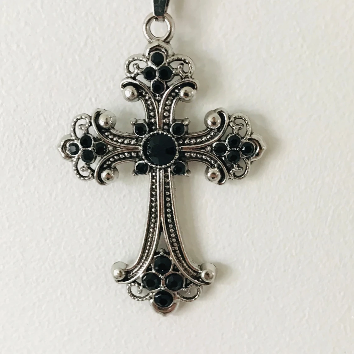 Silverfärgat korshalsband med svarta stenar
