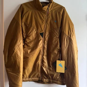 Klättermusen jacka primaloft - Säljer en brun klätterjacka från Klättermusen med PrimaLoft-isolering. Jackan har en dragkedja framtill och är designad för klättring. Perfekt för utomhusaktiviteter med sin funktionella och stilrena design.