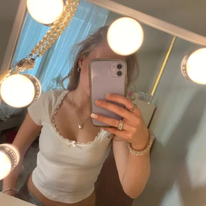 Vit ribbad kortärmad topp - Säljer en söt vit ribbad topp med en liten rosett. Från H&M