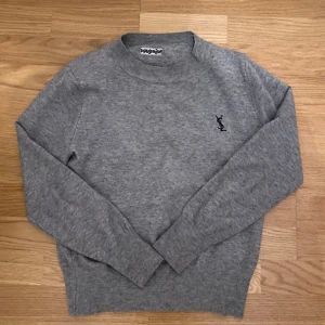Grå tröja från Yves Saint Laurent - Snygg grå tröja från Yves Saint Laurent | tröjan är storlek S men har krympt lite i tvätten så sitter som XS | såklart äkta | fraktar inom 30 minuter efter köp | pris går att diskutera | Köptes för 2900