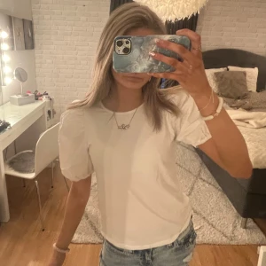 Vit t-shirt med puffärmar - Säljer en stilren vit t-shirt med puffärmar. Perfekt för en enkel och chic look. Har en minmal fläck (bild 2)💕