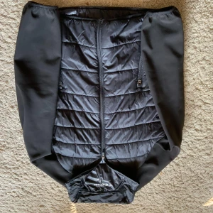 Svart jacka från Everest - Säljer en svart jacka från Everest med quiltad design och dragkedja framtill. Jackan har långa ärmar och är perfekt för kyligare dagar. Den är stilren och enkel att matcha med olika outfits.