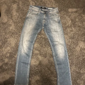 Blå jeans från Replay - Snygga blå jeans från Replay med en klassisk femficksdesign. De har en straight passform och är tillverkade i denim. Perfekta för en avslappnad stil. W 28, L 32. Ordinarie pris 1299