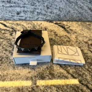 Valentino armband mörkgrön - Snyggt mörkgrönt armband från Valentino med silverfärgade nitar. Armbandet har ett justerbart spänne för perfekt passform. Väldigt bra skick. Kvitto och extra nitar ingår men tyvärr ingen original låda!