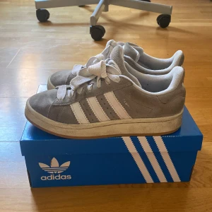 Gråa Adidas Campus 00s - Väldigt fina gråa Adidas Campus 00s, bara använda under sommaren 2024. Jag kan tvätta de ifall det är någon som vill! Köpt för 1300kr