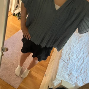 Plisserad blå blus från Samsøe Samsøe - Säljer en chill plisserad blus från Samsøe Samsøe i en snygg blå färg. Blusen har v-ringning, korta ärmar och loose passform. Materialet är lätt och flowy. Vet ej storleken men skulle säga att det är en L typ XL men jag på bilden är vanlig en Xs s så den passar alla.