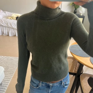 Mörkgrön polotröja i kashmir Ann Taylor - Superskön mörkgrön polotröja från Ann Taylor i 100% kashmir. Tröjan har lång ärm, ribbad polokrage och ribbade muddar vid ärmslut och nederkant. Väldigt bra skick!