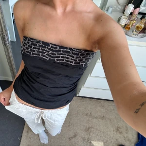 Svart bandeau tubtopp med pärlor - Snygg svart bandeau tubtopp med pärldetaljer från Zara. Toppen är axelbandslös. Är i gott skick å knappt använd💕 skriv för frågor eller funderingar🥰