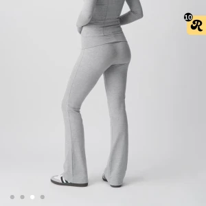 Grå yoga pants - Snygga yoga pants med bootcut och bred, vikbar midja. Byxorna har en mjuk och stretchig känsla, perfekta för chill eller träning. Passformen är loose och de har en enkel, stilren look utan detaljer eller mönster. Använd väldigt fåtal gånger, ca 2-3 ggr