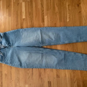 Ljusblå jeans från H&M Divided, strl 34 - Säljer ett par ljusblå jeans från H&M Divided i storlek 34. Jeansen har klassisk femficksdesign, raka ben och normal passform. Materialet är jeans med snygga slitningar och ljus tvätt. Perfekta för en chill och avslappnad stil.