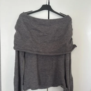 Grå offshoulder stickad tröja Romwe - Säljer en grå stickad tröja från Romwe i storlek XS. Tröjan har en snygg offshoulder-design med bred krage och långa ärmar. Materialet är mjukt och består av akryl, polyester och polyamid. Perfekt för dig som gillar chill och trendiga vibes.