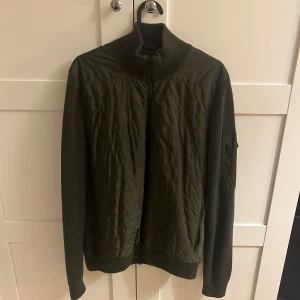 Mörkgrön cardigan jacka från J.Lindeberg - Mörkgrön J.Lindeberg cardigan i mycket bra skick inga defekter använd fåtal gånger. Perfekt nu för hösten och sen sommar. Hör av er om ni har fler frågor.