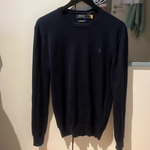 Stickad tröja Ralph lauren - Säljer min mörkblå merinoull tröja från Polo Ralph Lauren. Tröjan är stickad i högkvalitativ merinoull och är slim fit. Riktigt snygg, passar till allt. Storlek M passar även S. Nypris 2400:- säljer för 849:- tröjan är i bra skick, ända bekymret är liten slitning på höger arm (bild 3) syns lite om man kollar noga men inget man tänker på vid användning. Kom gärna med bud eller frågor om det finns några!