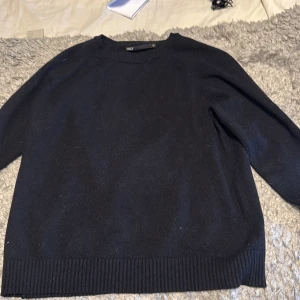 Svart stickad tröja från ONLY - En enkel och snygg svart stickad tröja från ONLY i storlek XS. Tröjan har rund hals, långa ärmar och ribbade muddar vid hals, ärmslut och nederkant. Perfekt för att hålla dig varm och stilren under kyliga dagar.