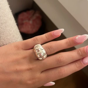 Chunky silverring med räfflad design - Säljer en chunky silverring med bred, räfflad form som ger en cool statement-look. Ringen har en blank finish och är riktigt iögonfallande. 