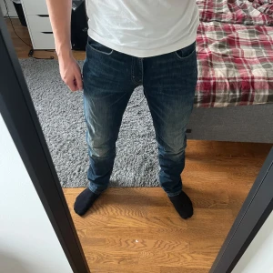 Levi's 511 blå jeans W30 L32 - Säljer ett par Levi's 511 jeans i mörkblå tvätt med snygga slitningar. Modellen är slim och har klassisk femficksdesign, knapp och dragkedja fram. Jeansen är tillverkade i jeansmaterial och har en modern, smal passform som sitter riktigt bra.