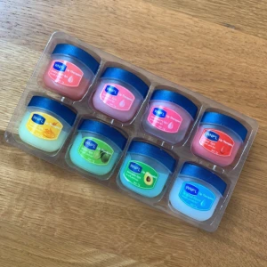 Läppbalsam set med 8 smaker - Säljer ett kit med 8 små burkar läppbalsam i olika smaker och färger, bl.a. honung, kiwi, avokado och original. Helt oanvända. 