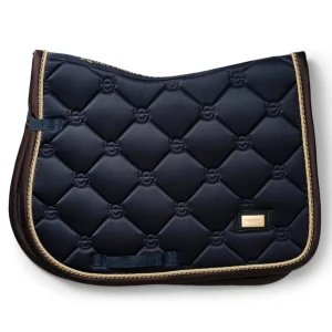 Equestrian Stockholm schabrak  - Snygg mörkblå quiltad sadelpad från Equestrian Stockholm med guldfärgad kant och diskret logomönster. Materialet är glansig polyester och formen är klassisk för dressyrsadel. Perfekt för dig som vill ha stil på ridbanan.